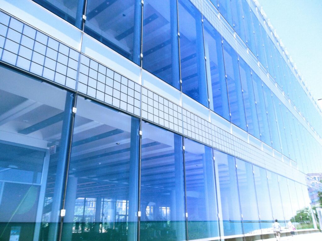 Contemporary glass building facade with reflections in the city, highlighting urban architecture.